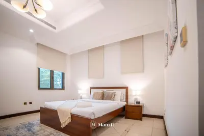 a white bedroom with a bed and two lamps at Lux 5BR Villa with Pool & Beach Access in Palm Jumeirah in Dubai