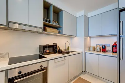 a kitchen with white cabinets and a sink at Private Beachfront 2 Bed With 180 Marina Skyline in Dubai