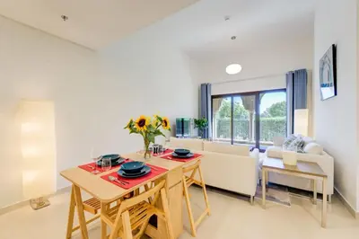 a living room with a table and a couch at Serene 2-Bed Haven in Jumeirah Golf Estates in Dubai