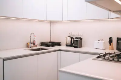 a white kitchen with white cabinets and appliances at Luma Escape Dubai in Dubai