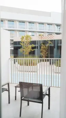 a black chair sitting on a balcony with a building at Luma Escape Dubai in Dubai