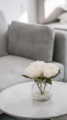 a glass vase with white flowers on a table at Luma Escape Dubai in Dubai