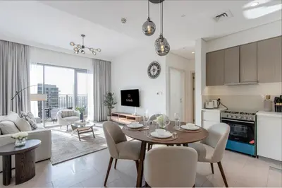 a kitchen and living room with a table and chairs at Livbnb - Stylish 1B in Park Heights Dubai Hills in Dubai