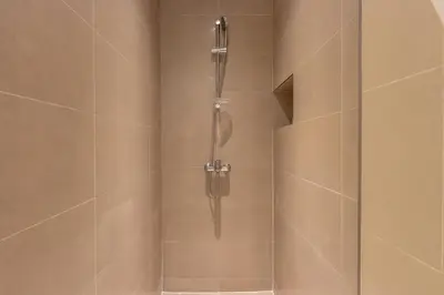 a bathroom with a shower with a glass door at Livbnb - Stylish 1B in Park Heights Dubai Hills in Dubai