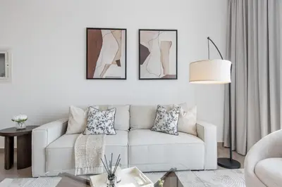 a living room with a white couch and a table at Livbnb - Stylish 1B in Park Heights Dubai Hills in Dubai