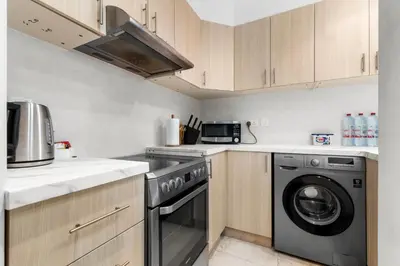 a kitchen with a dishwasher and a washer at Elegant One Bed Apartment - Panoramic Marina Views - Near JBR & Beach in Dubai