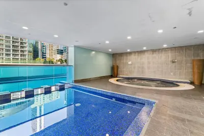 an indoor swimming pool with a large swimming pool at Elegant One Bed Apartment - Panoramic Marina Views - Near JBR & Beach in Dubai