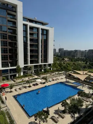 a large swimming pool in front of a building at Shared Apartment In Dubai Hills in Dubai