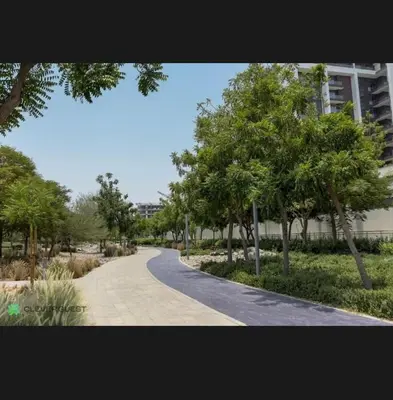 a winding road in a park with trees and a building at Shared Apartment In Dubai Hills in Dubai