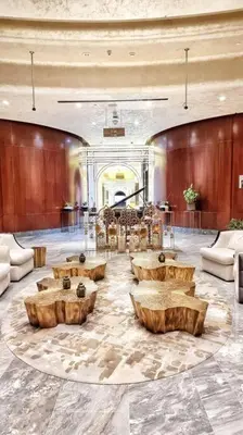 a lobby with wooden tables and chairs in a building at 1BR Tower B Paramount Apartment in Dubai
