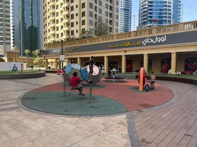 a person sitting on a statue in front of a building at Bright apartment in JBR few steps from the beach in Dubai