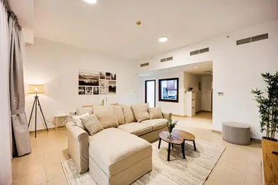 a living room with a couch and a table at Bright apartment in JBR few steps from the beach in Dubai