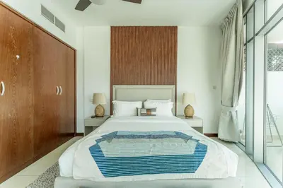 a bedroom with a large bed and a large window at HAVN - 1 Bedroom Apartment in Villa Pera, JVC in Dubai