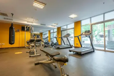 a gym with a bunch of treadms and machines at HAVN - 1 Bedroom Apartment in Villa Pera, JVC in Dubai