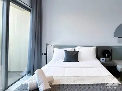 a bedroom with a bed with white sheets and pillows at Modern Meydan Studio with Private Balcony in Dubai