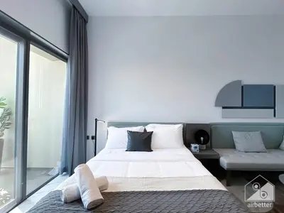 a bedroom with a bed and a large window at Modern Meydan Studio with Private Balcony in Dubai