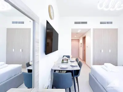 a dining room with a table and two beds at Balcony Studio Haven in Riviera in Dubai