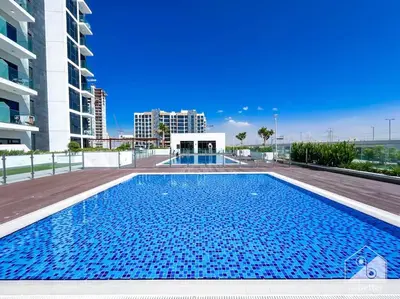 a large blue swimming pool in a building at Balcony Studio Haven in Riviera in Dubai