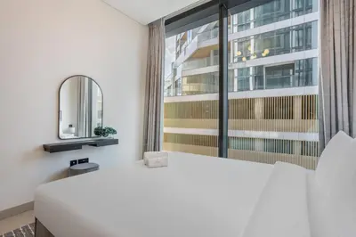 a bedroom with a large white bed and a window at STAY BY LATINEM Luxury 2BR Holiday Home W205 near Burj Khalifa in Dubai