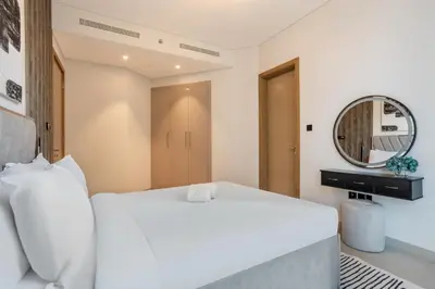a bedroom with a white bed and a mirror at STAY BY LATINEM Luxury 2BR Holiday Home W205 near Burj Khalifa in Dubai