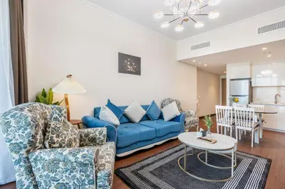 a living room with a blue couch and chairs at Clse Elegance Redefined Luxury 1 Bedroom Apartment with Premium Facilities in Dubai