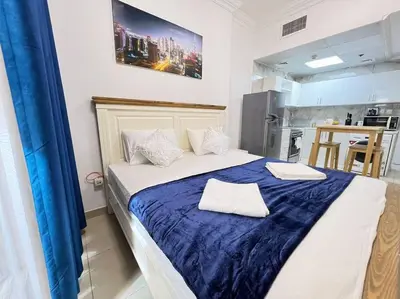 a bedroom with a large bed with a blue blanket at Brand New and Stylish Interior in Dubai