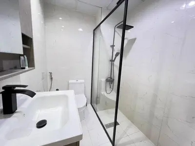 a bathroom with a shower and a sink and a toilet at Brand New and Stylish Interior in Dubai