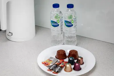 a plate with two bottles of water and chocolates at Bright 1BR with balcony in Luma 22 in Dubai