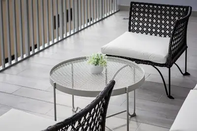 a table and a chair with a potted plant on it at Bright 1BR with balcony in Luma 22 in Dubai