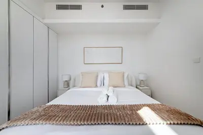 a bedroom with a bed with two white towels on it at Bright 1BR with balcony in Luma 22 in Dubai