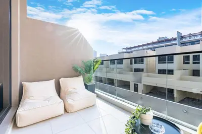 a balcony with a couch and a view of a building at Stylish Contemporary Home in JVC with Chic Interior in Dubai