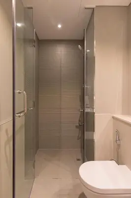a bathroom with a shower with a toilet and a sink at Modern and Cozy 1BR in Business Bay in Dubai