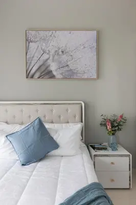 a bed with a blue pillow and a picture on the wall at Modern and Cozy 1BR in Business Bay in Dubai