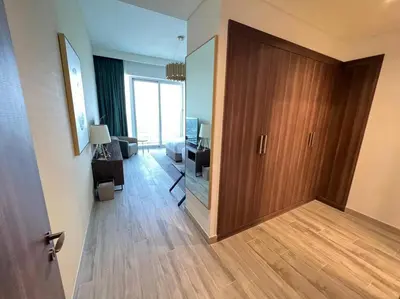 a room with a wooden door and a living room at Luxury 2BR Avani Palm View Apt in Dubai