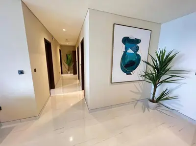 a hallway with a painting and a plant on a wall at Luxury 2BR Avani Palm View Apt in Dubai