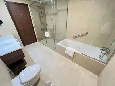 a bathroom with a shower and a toilet and a sink at Luxury 2BR Avani Palm View Apt in Dubai