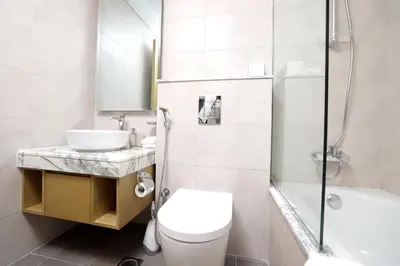 a bathroom with a toilet and a sink and a shower at Chic Aykon City 2-Bedroom Retreat - Business Bay in Dubai
