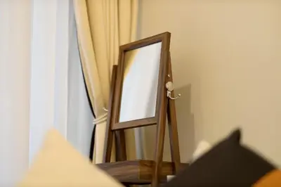 a mirror on a stand next to a curtain at Chic Aykon City 2-Bedroom Retreat - Business Bay in Dubai