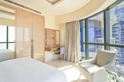 a hotel room with a bed and a desk and chairs at Spacious 3BHK in Paramount Tower B with Stunning Views-6204 in Dubai