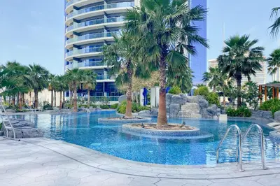a swimming pool with palm trees in a resort at Spacious 3BHK in Paramount Tower B with Stunning Views-6204 in Dubai