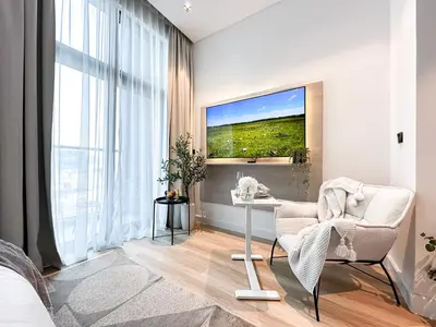 a living room with a white chair and a table at Modern Marvel Studio in Business Bay in Dubai