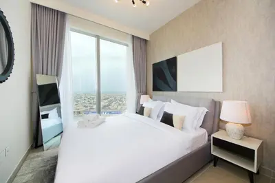 a bedroom with a large bed with a large window at Downtown Luxury - Stunning 2BHK with Sea view in Forte towers, Downtown in Dubai