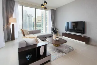 a living room with a couch and a flat screen tv at Downtown Luxury - Stunning 2BHK with Sea view in Forte towers, Downtown in Dubai