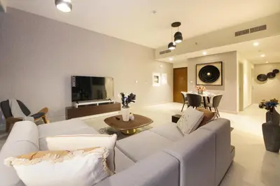 a living room with a white couch and a table at Downtown Luxury - Stunning 2BHK with Sea view in Forte towers, Downtown in Dubai