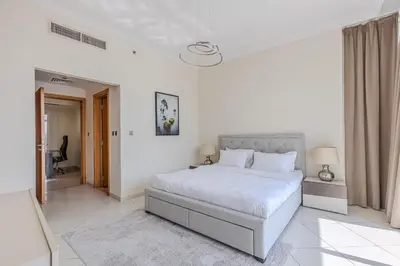 a white bedroom with a bed and a hallway at Spacious 3BDR Apartment in Marina with Office in Dubai