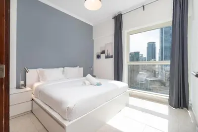 a bedroom with a white bed and a large window at 2 Bedroom Apartment full Marina View in Dubai