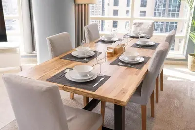a wooden table with chairs and plates and glasses on it at 2 Bedroom Apartment full Marina View in Dubai