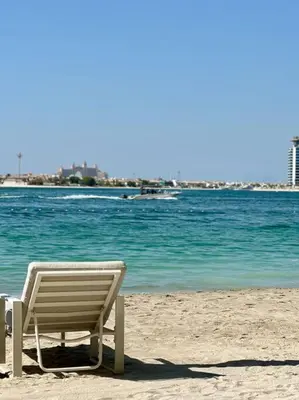 a beach chair sitting on the sand on the beach at BrandNew, OceanView, PrivateBeach, 1bed in Dubai