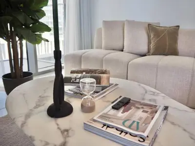a living room with a coffee table with a vase on it at BrandNew, OceanView, PrivateBeach, 1bed in Dubai