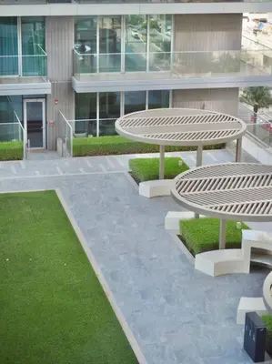 a patio with a table and benches in front of a building at BrandNew, OceanView, PrivateBeach, 1bed in Dubai